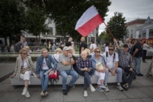 Polonia al borde del abismo A man waves the Polish flag as they wait to hear Donald Tusk