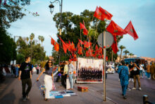Tourists walking by moroccan flags street stall on a street