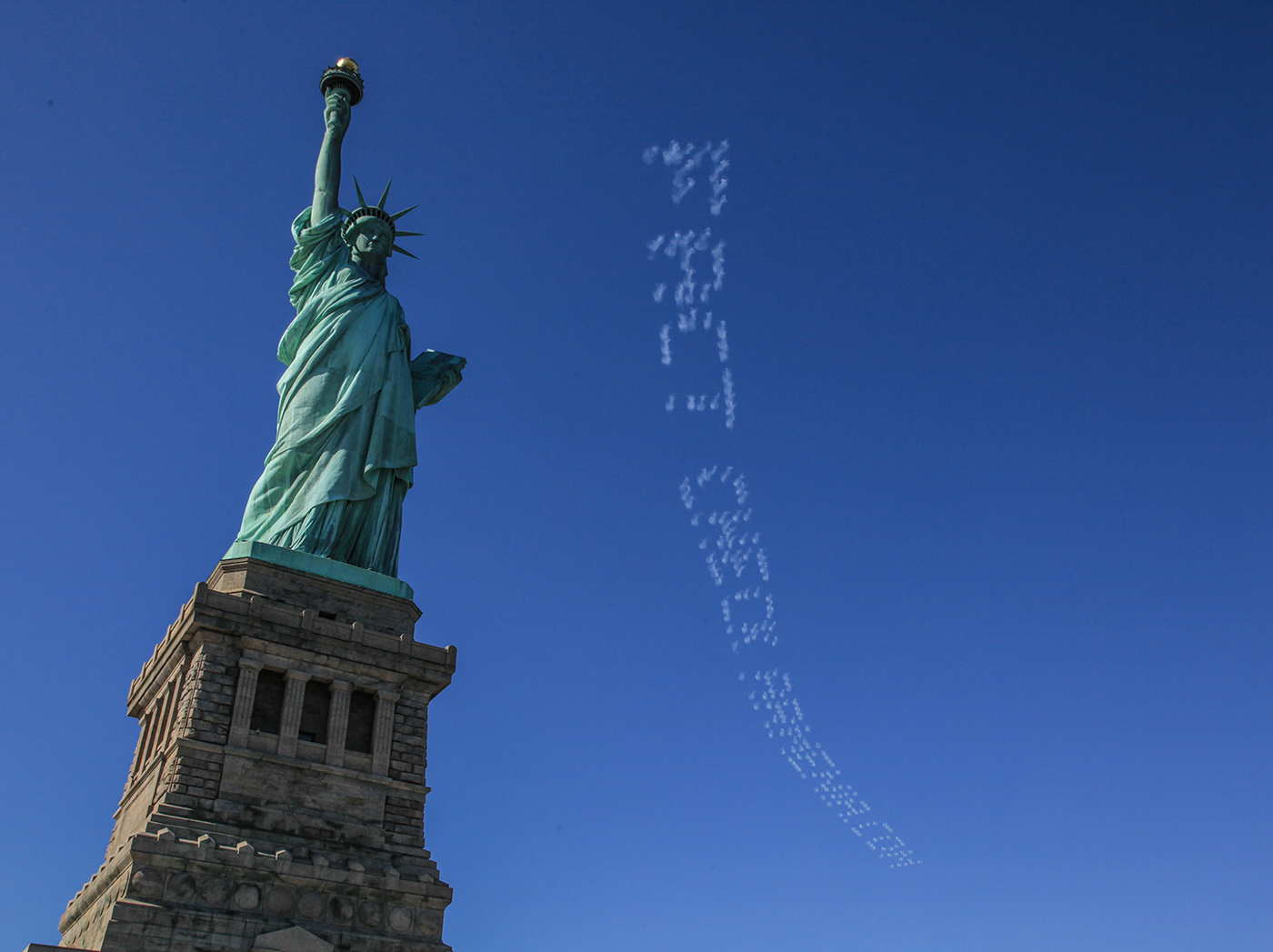 NEW YORK, UNITED STATE - APRIL 21: Plane skywriting saying "Fact Check Armenia.Com" is seen over the Statue of Liberty in New York, United States on April 21, 2016. Turkish institution founded in Washington organized 'Turkish feast' in response to the Armenian claims on 1915 incidents. Rented plane wrote ''Truth=Peace", "Stop: PYD=PKK=ASALA=DAESH'', ''101 years of Geno-lie" in the sky and young dance group perform peace choreography with Turkish flags during the 'Turkish feast'. (Photo by Cem Ozdel/Anadolu Agency/Getty Images)