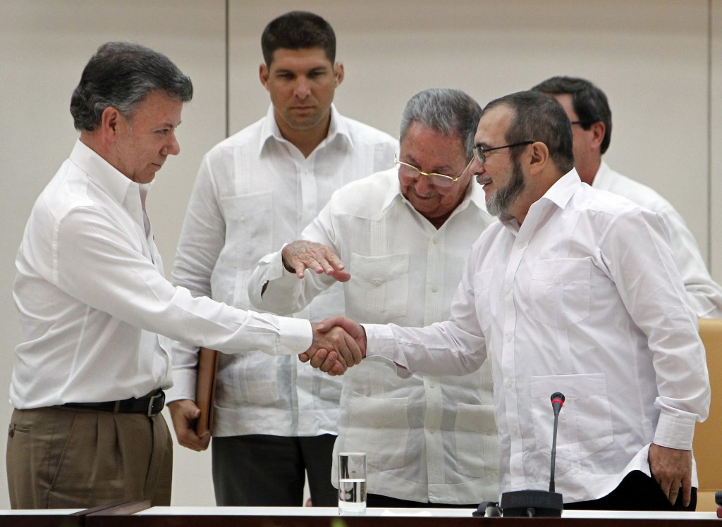 Conversacinoes de paz La Habana. Santos y Timochenko se dan la mano ante Raúl Castro.